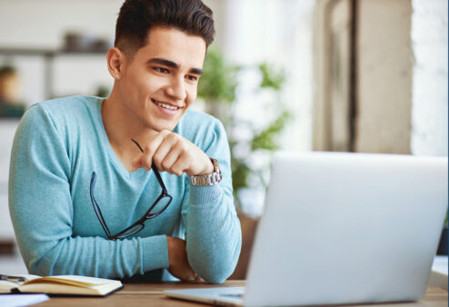 Young adult in front of laptop computer.
